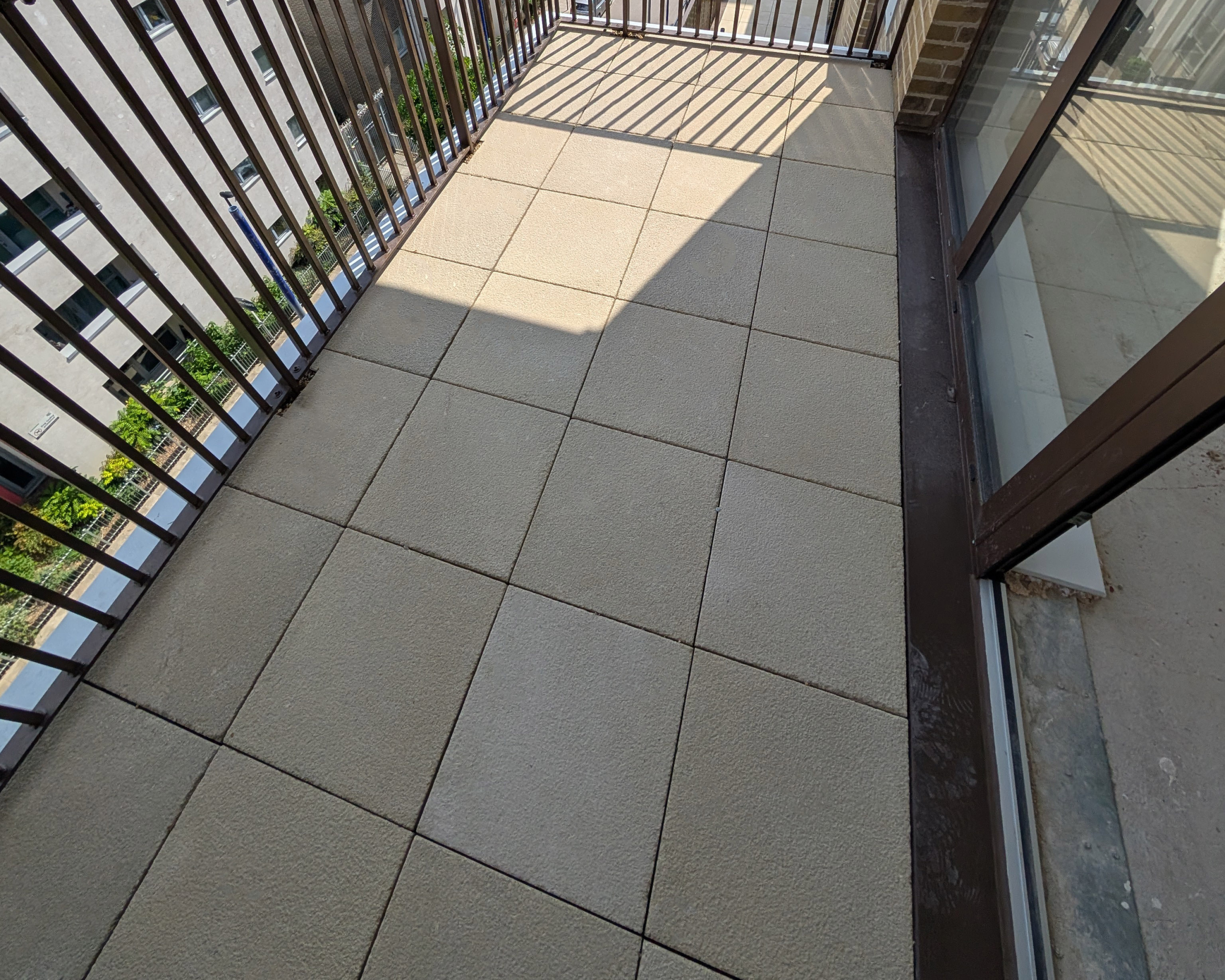 Hot Melt Roofing South East – paved rooftop walkway area with slab tiles over waterproofing system