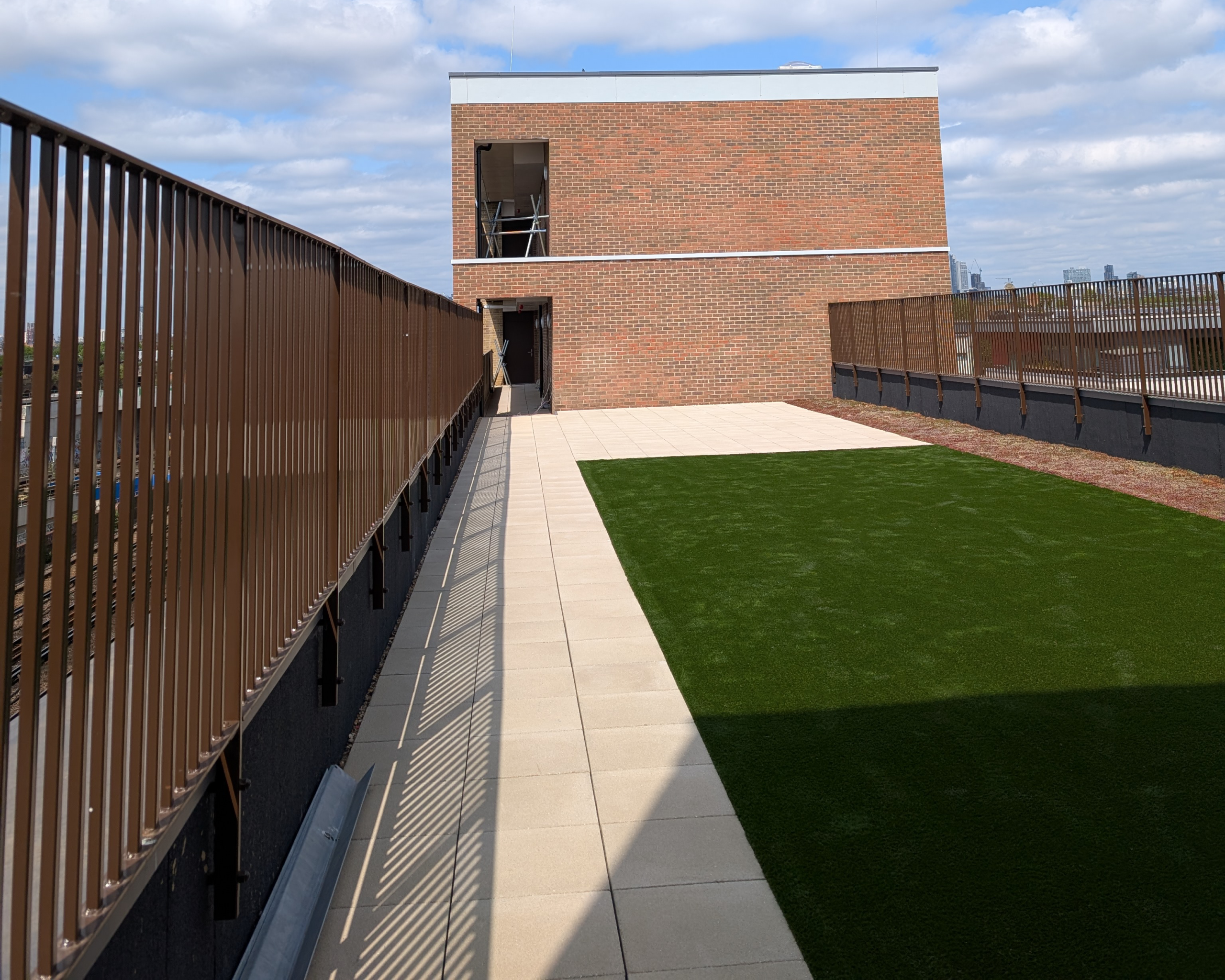 Hot Melt Roofing South East – finished rooftop terrace with artificial grass and paved walkway over hot melt waterproofing system