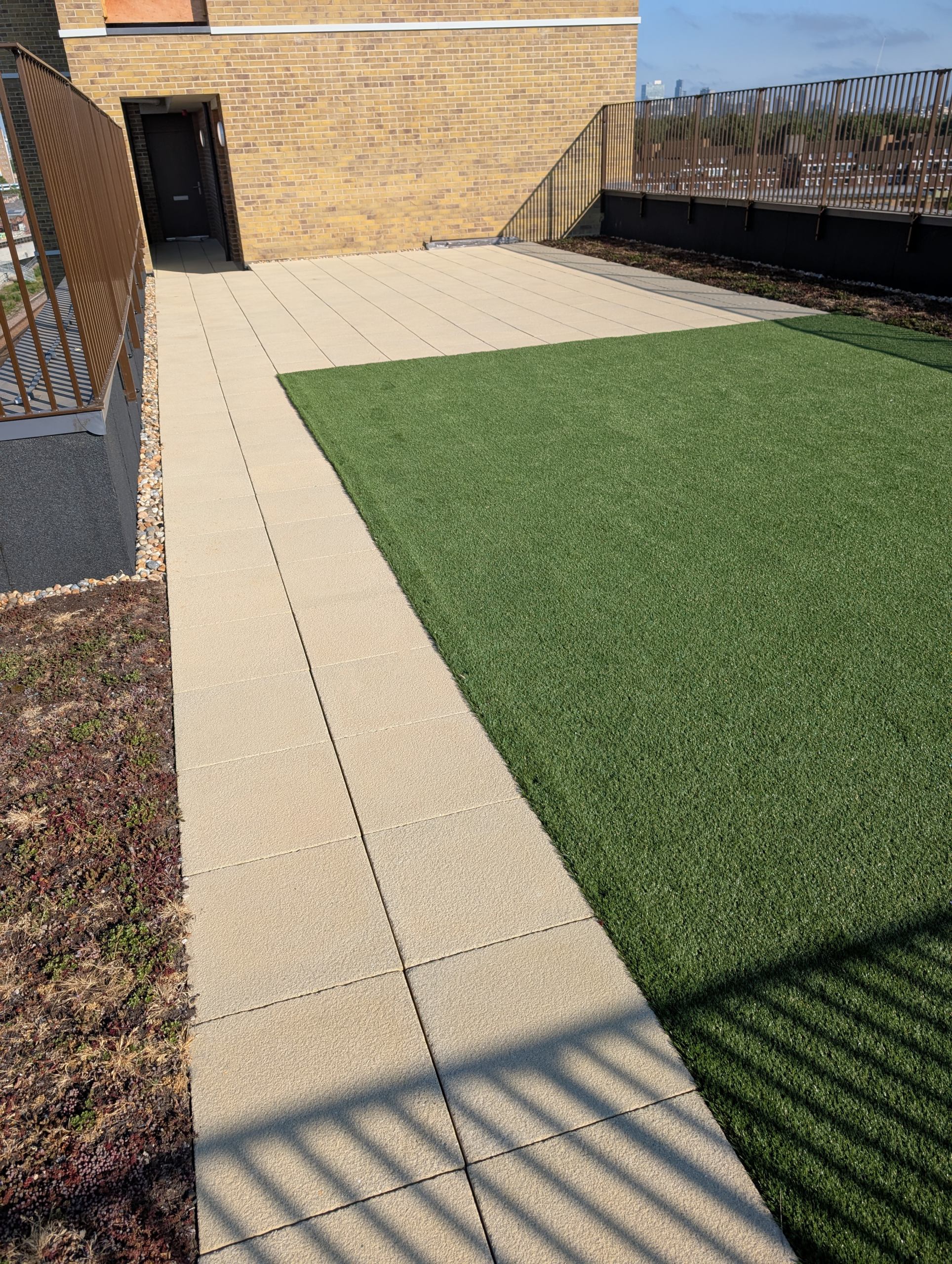 Hot Melt Roofing South East – finished roof terrace with artificial grass and paving tiles on flat roof