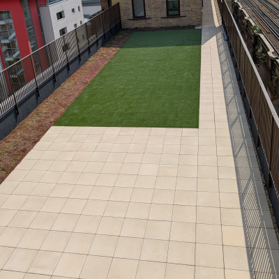 Hot Melt Roofing South East – rooftop deck with central artificial lawn and paved perimeter walkway