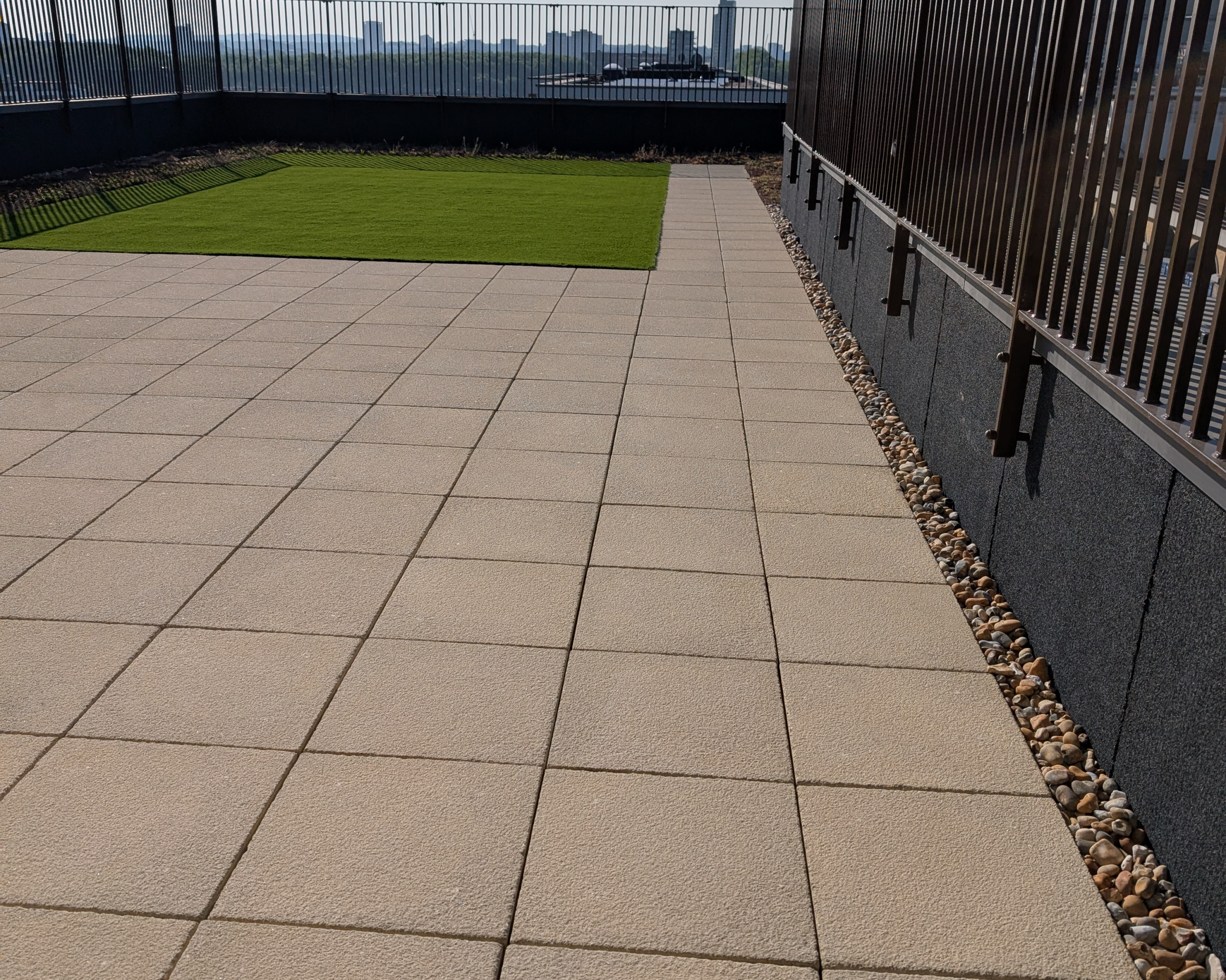 Hot Melt Roofing South East – large rooftop space with green surface and paved access path