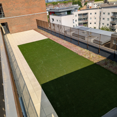 Hot Melt Roofing South East – elevated roof terrace with green landscaping and paving overlooking city buildings