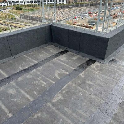 Hot Melt Roofing South East – flat roof installation with parapet detailing overlooking railway tracks