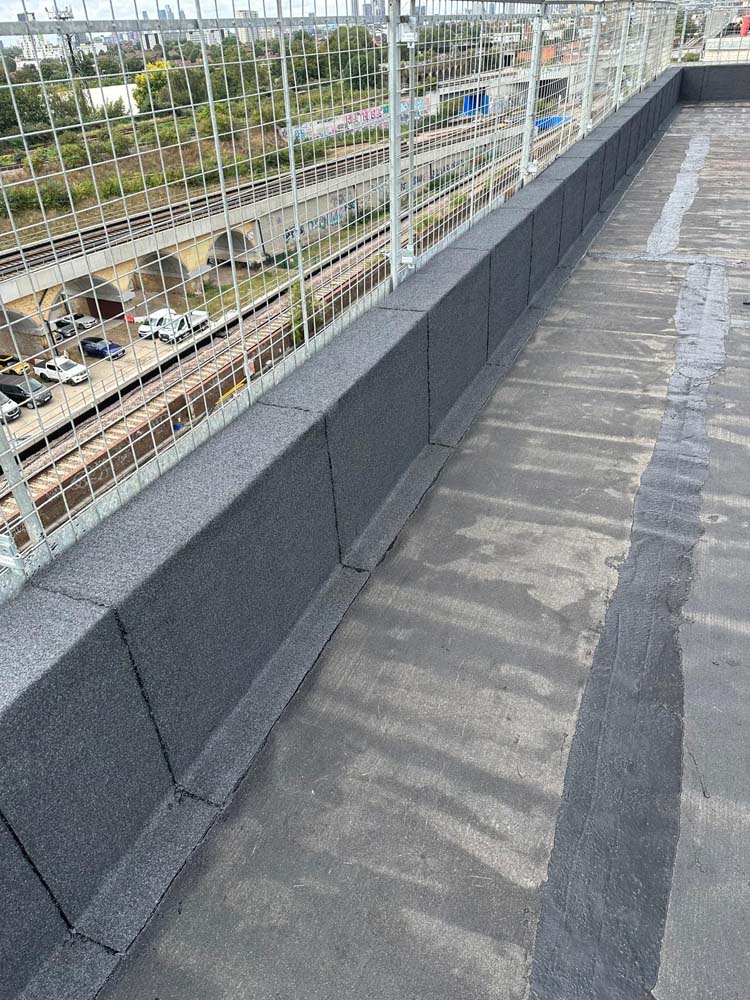 Hot Melt Roofing South East – long parapet edge section with completed hot melt waterproofing on high-rise building