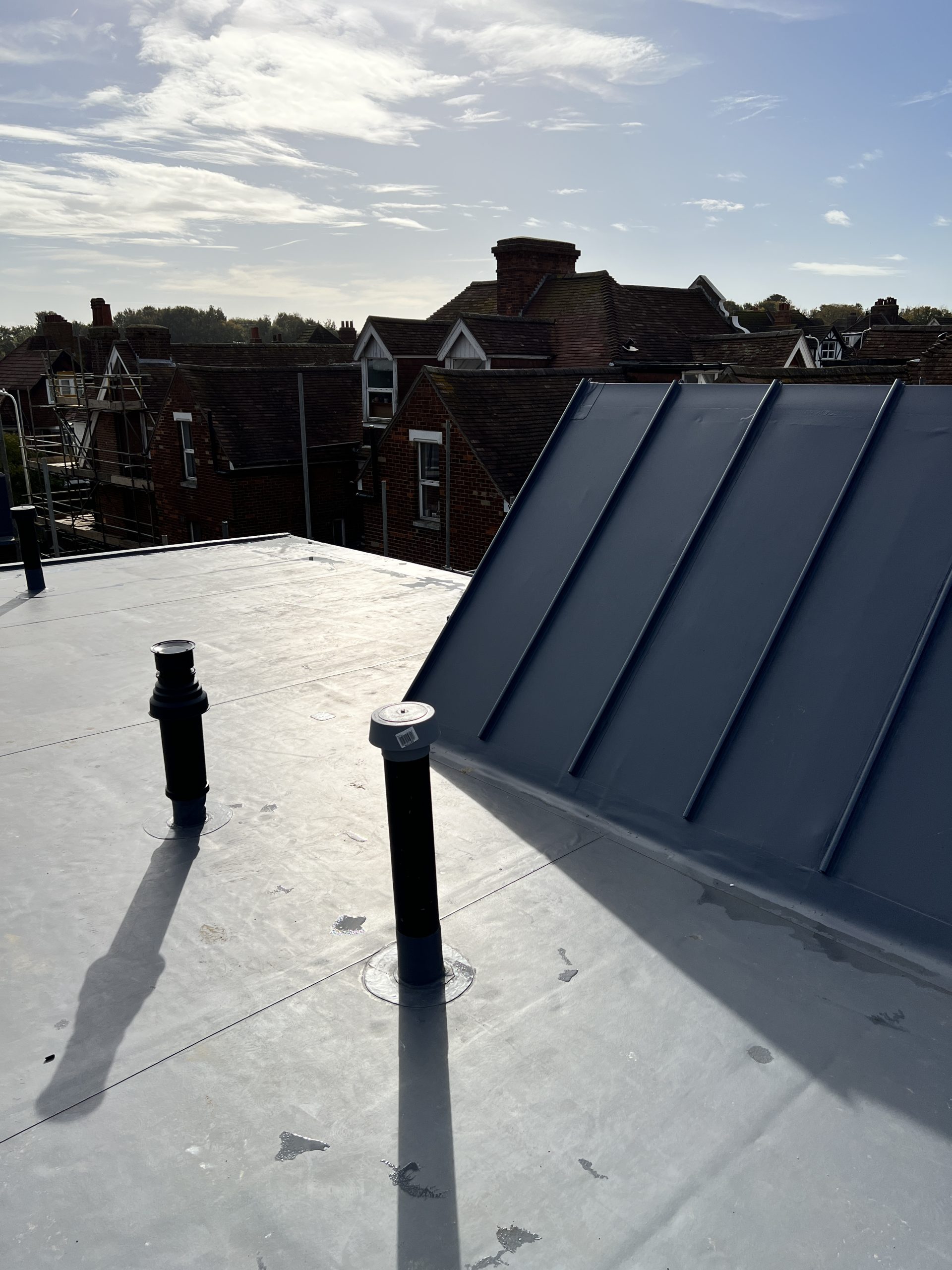 Single ply roof and vertical upstand junction on residential building with clear sky