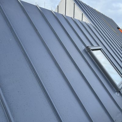Angled view of single ply roofing membrane on pitched roof with integrated skylight