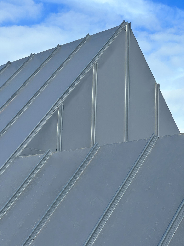 Cleanly installed single ply vertical roof cladding system with geometric seam lines