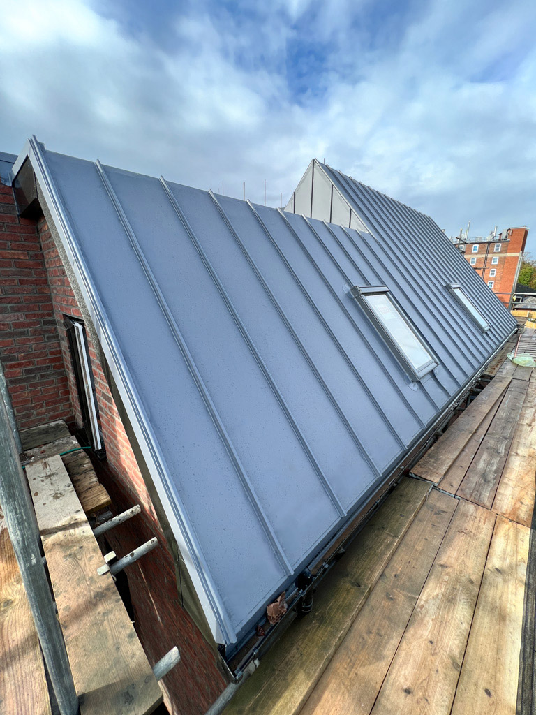 Single ply roofing on pitched dormer roof with skylight during installation
