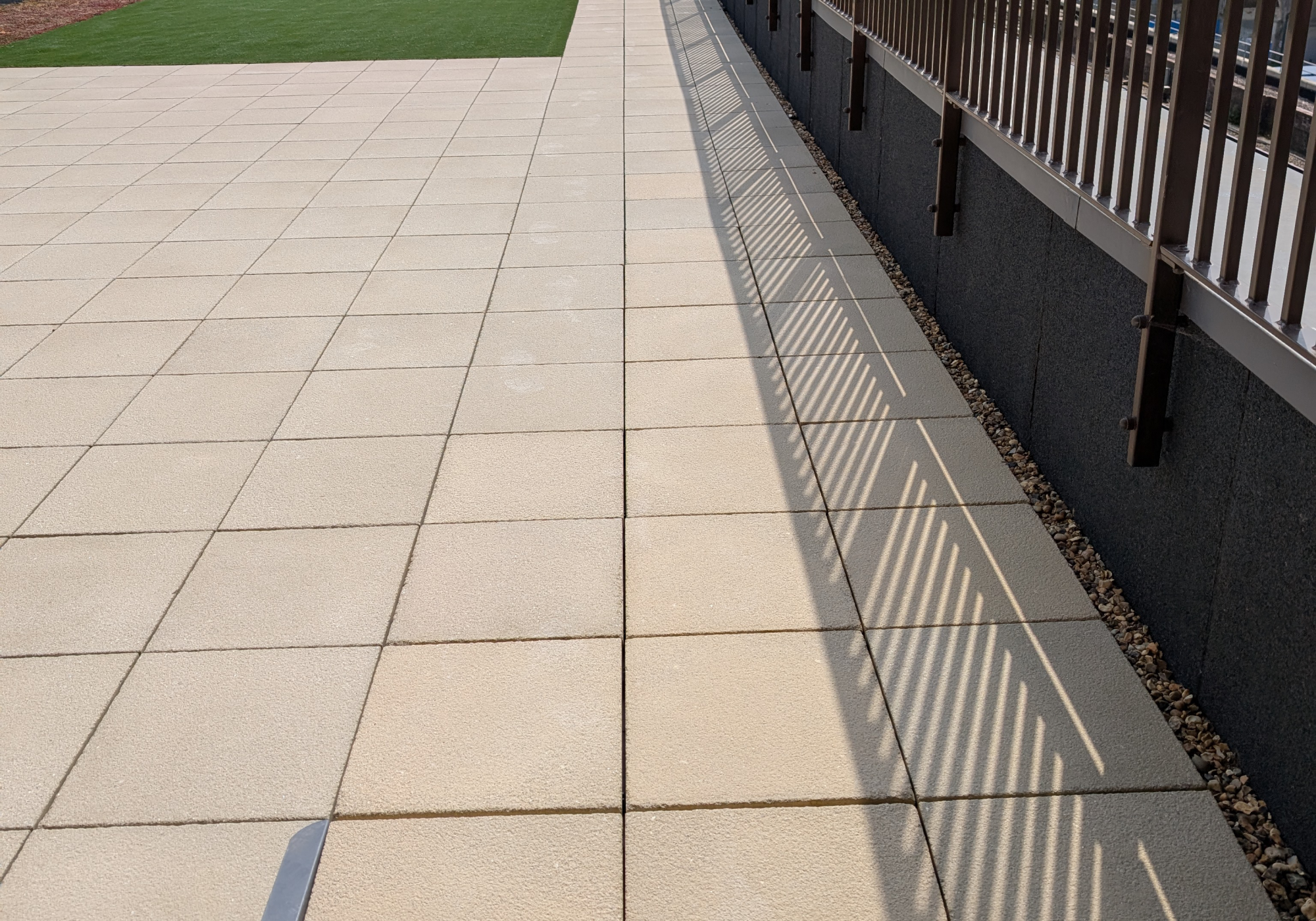 Concrete slab patio with artificial grass and a sedum roofing system on a brand-new roof terrace in London- AJ Lucas Roofing | Roofing Contractors South East & London