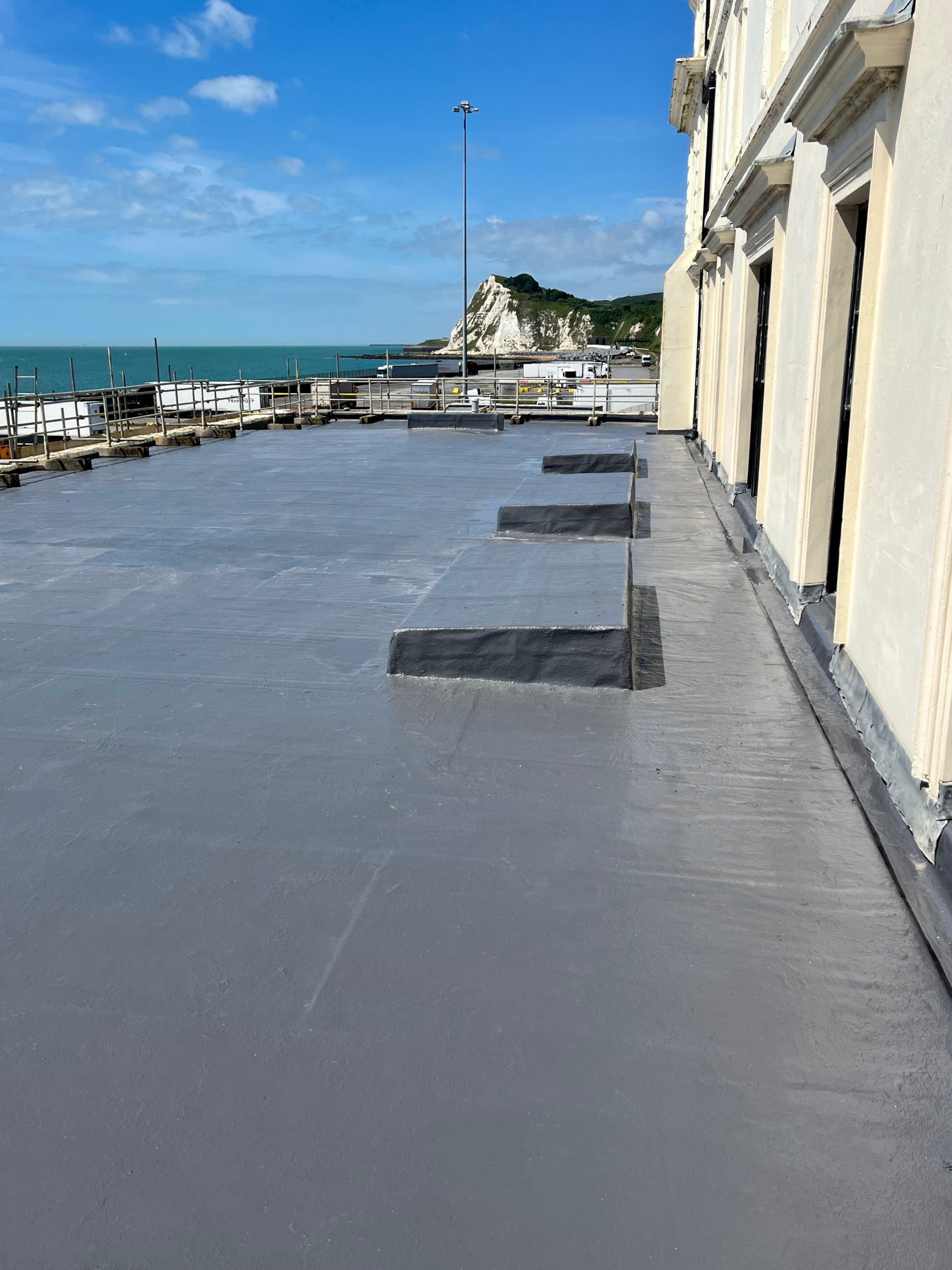 A flat roof covered with a liquid roofing system using the SIGnature Ultra Protect PU product. The flat roof over looks the White Cliffs of Dover and the Dover Port. AJ Lucas Roofing Contractors Serving Kent, London & South East