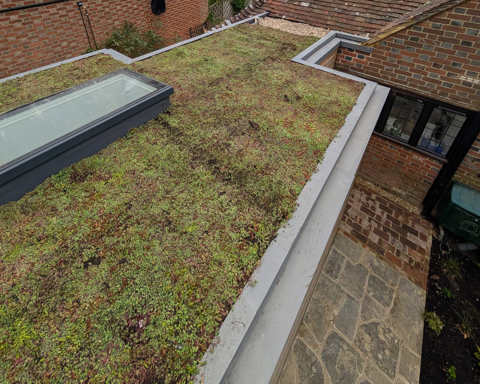 Green Roofs South East – sedum roof detail with skylight and stone pathway below