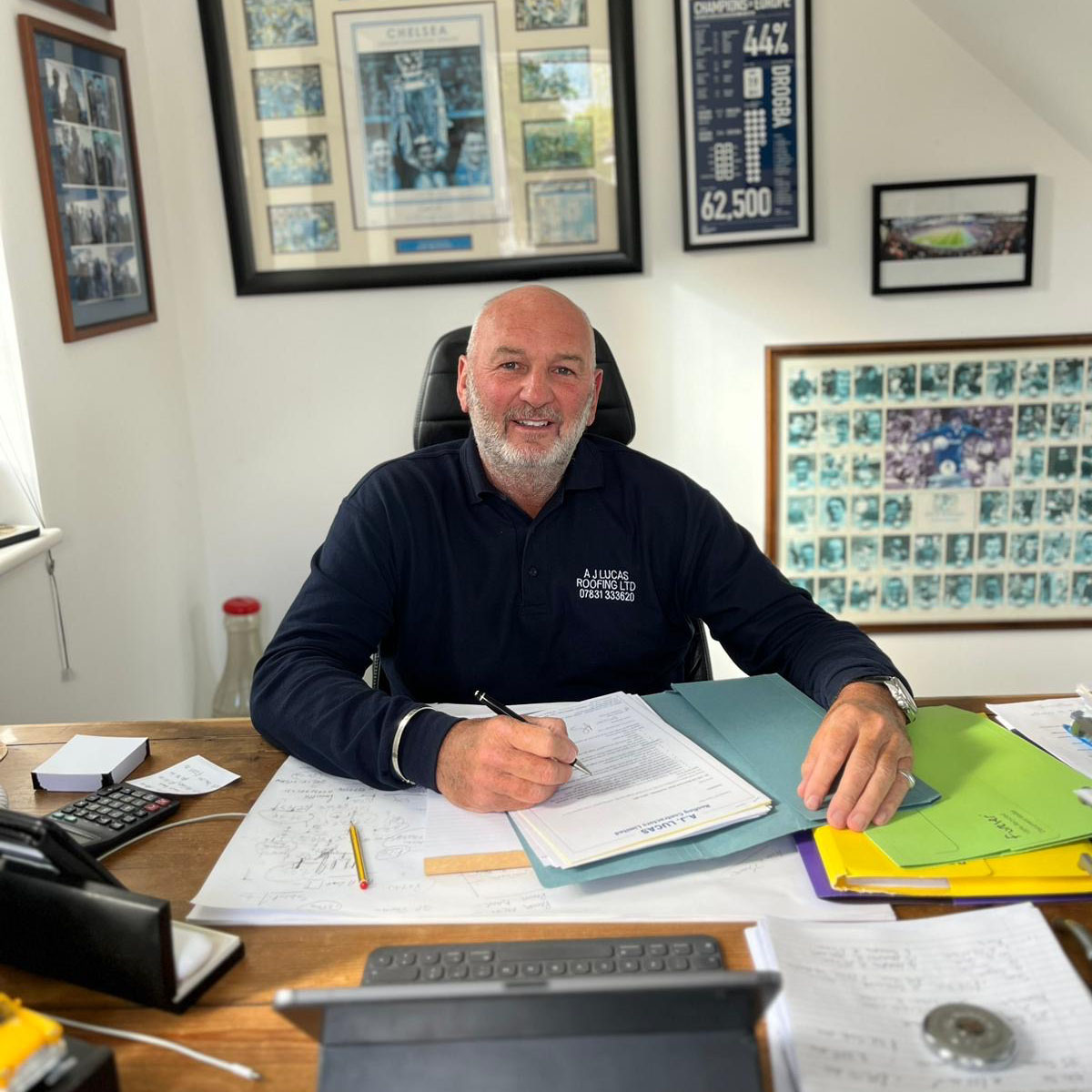 Antony Lucas, founder of A J Lucas Roofing Contractors serving Kent, London & South East, working at his desk in the company office. 