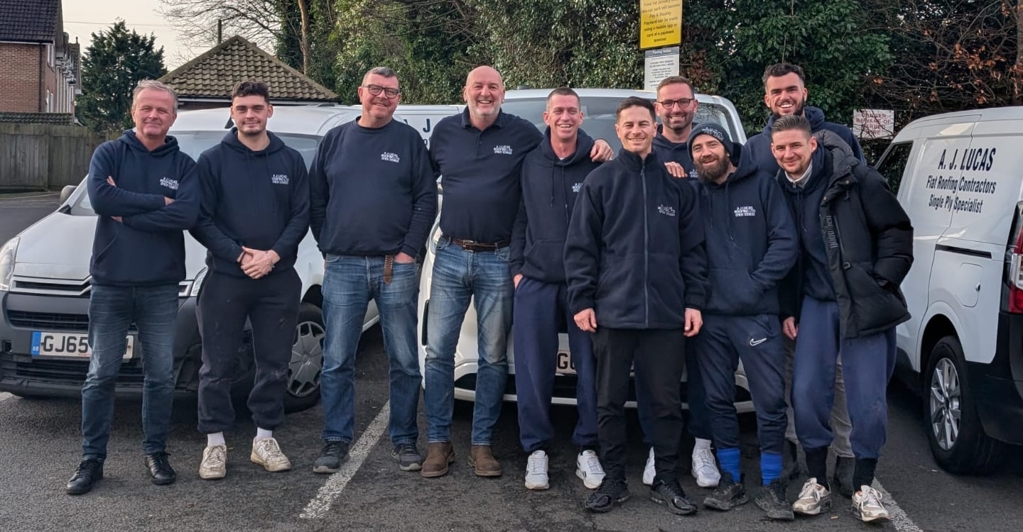 The A J Lucas Roofing Contractors team, serving Kent, London & South East, standing in front of company vans in Kent. 